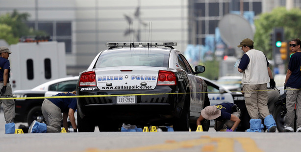 Investigators work in the area of downtown Dallas that remains an active crime scene. Photo/AP