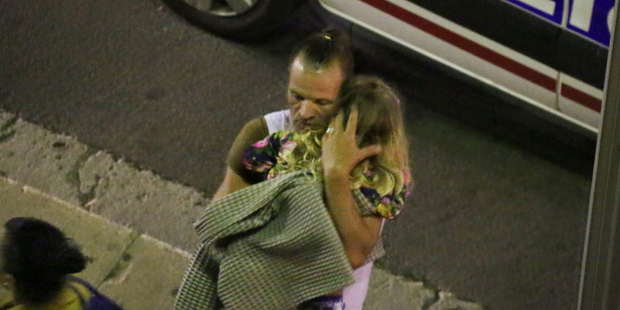 A man holds a child after the attack. Photo / AP