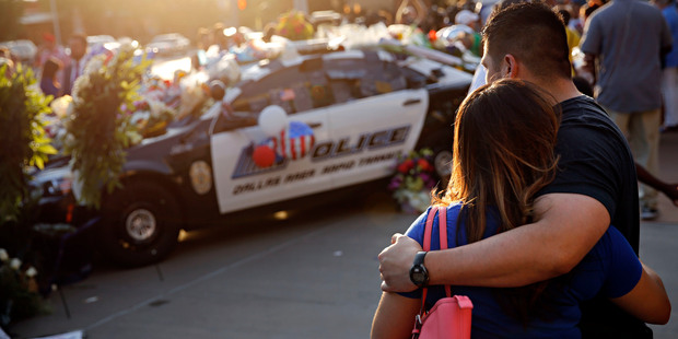 Luis Sone, right, and his girlfriend, Maritza Garcia, look at a vigil in front of Dallas police headquarters. Photo / AP