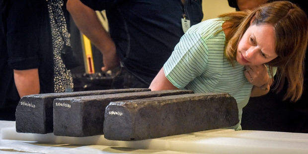 Connie Beninghove, assistant registrar, inspects Iron ballast bars recovered from a shipwrecked slave ship and destined for the African American museum. Photo / Washington Post