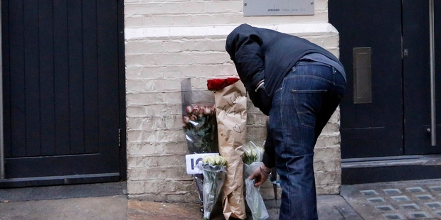 A man places flowers at his birthplace at Brixton in London. Photo / AP