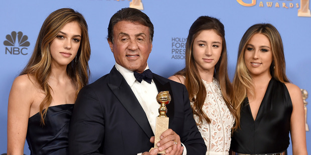 Sylvester Stallone holds his Golden Globes trophy for best performance by an actor in a supporting role alongside Sophia Stallone, Scarlet Stallone and Sistine Stallone. Photo/AP
