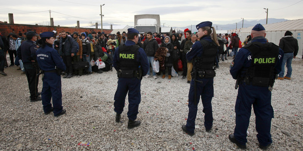 Hungarian police officers keep order as migrants wait to board a train towards Serbia, on their way north to more prosperous European Union countries. AP photo / Boris Grdanoski