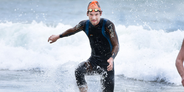 Andrew Lloyd reaches the beach ahead of the finish of Sunday's Round the Mount swim. Photo / George Novak