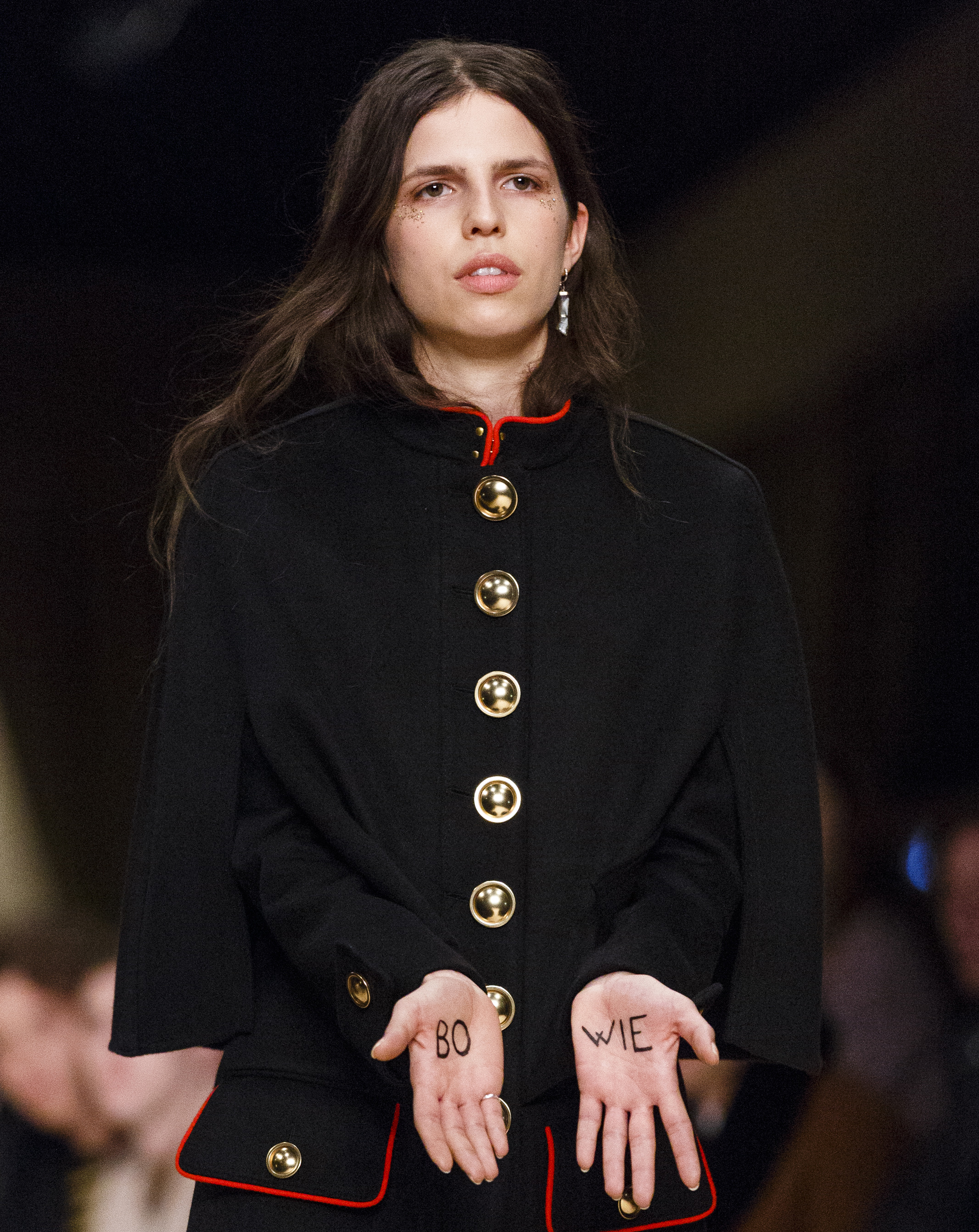 A model with 'Bowie' written on her hands walks the runway at the Burberry show during The London Collections Men AW16. Photo / Getty
