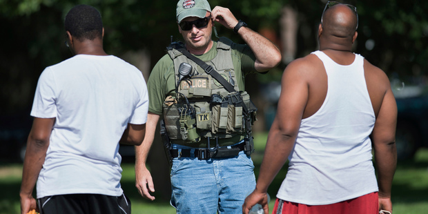 A US Marshall talks to people as authorities investigate an area in Kansas City, Missouri, in relation to the Baton Rouge shootings. Photo / AP