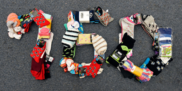 Kaysi Fredericks is holding photography sessions of people jumping in puddles all for a donation of a pair of socks for those in need. She has 160 pairs so far. Photo/George Novak