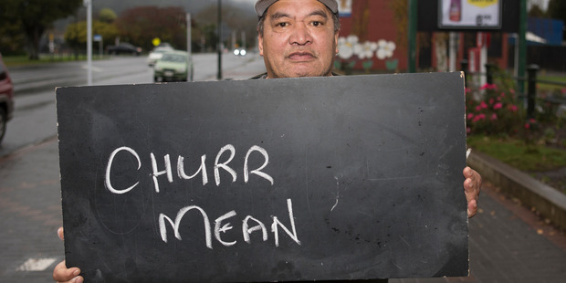 Frank Tahana in Ngaruawahia with a chalkboard message on what it means to be a New Zealander. Photo / Mark Mitchell