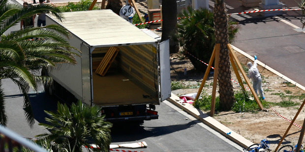 Police officers work near the truck that mowed through revellers in Nice. Photo / AP