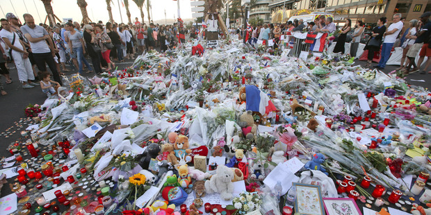 People gather at a makeshift memorial to honour the victims of the Nice attack. Photo / AP