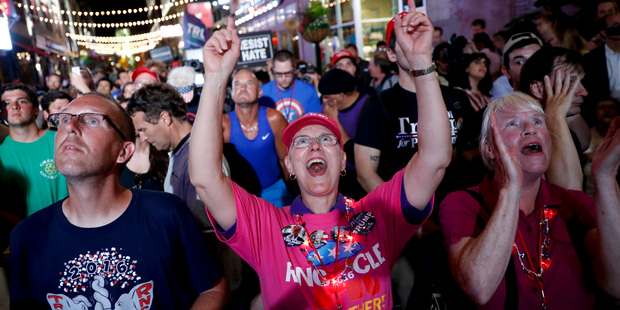 Supporters watch Republican presidential candidate Donald Trump speak on a outdoor screen in downtown Cleveland, during the final day of the Republican convention. Photo / AP
