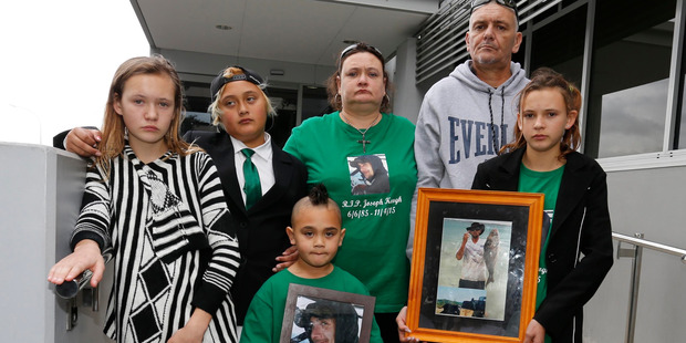 Joseph Rowland Keogh's family with a photo of him outside court after the sentencing. From left, sister Angel-Aroha, sons Vince Patrick and Kupe, parents Morag and Rowland, and sister Jacinta.
