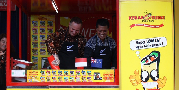 Prime Minister John Key and Indonesian entrepreneur Hendy Sentiono make kebabs in Surabaya, Indonesia. Photo / Isaac Davison