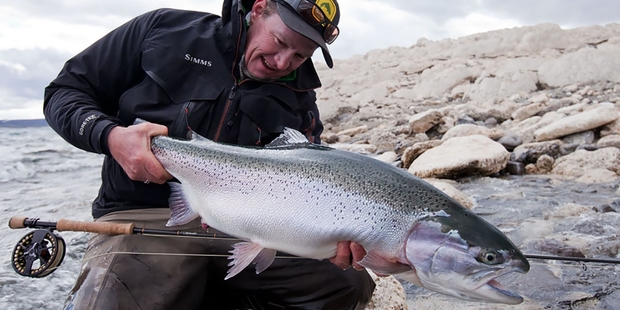 Nick Reygaert takes a break from filming to catch a giant rainbow trout in Patagonia. Picture / Geoff Thomas