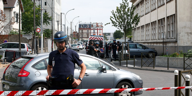 Riot police stand guard next to a building where French anti-terrorist forces conducted raids, in Argenteuil, west of Paris. Photo / AP