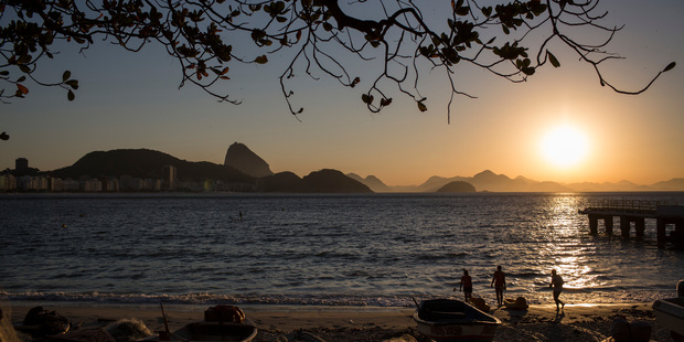People exercise along Copacabana Beach as the sun rises in Rio de Janeiro, Brazil. Photo / AP