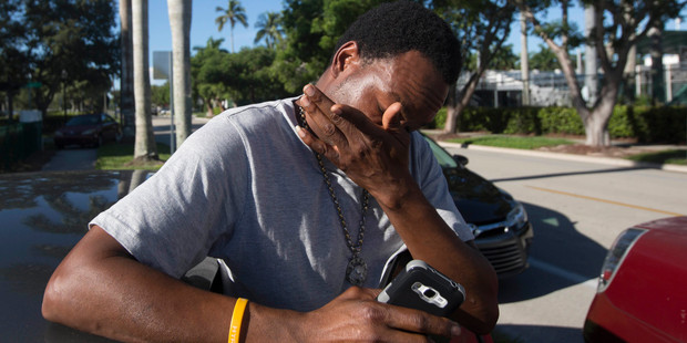 Jean Robert Archilles reacts, while speaking about the death of his son, Shawn Archilles, 14, who was killed in a shooting at Club Blu. Photo / AP