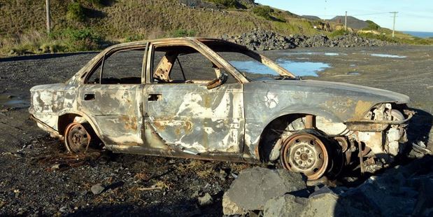 A torched car at Blackhead in Dunedin yesterday is part of a string of cars that have been stolen, then set on fire. Photo / Otago Daily Times