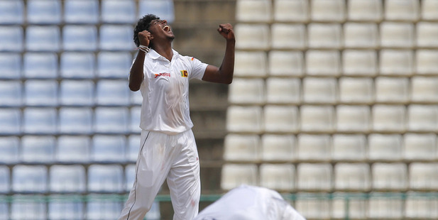 Sri Lanka's bowler Lakshan Sandakan celebrates as Kusal Mendis, foreground takes a catch to dismiss Australia's Steve O' Keefe. Photo / AP