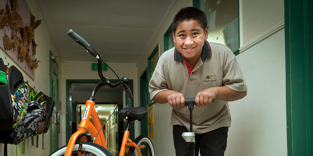 WHEELY GOOD: Fatui Tonga, 9, helps pump up the tyres of the donated bikes to Gate Pa school. PHOTO/Andrew Warner.