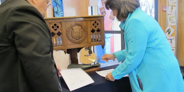 Kaumatua John Maihi signing the education MoU on behalf of Te Puna Matauranga o Whanganui with Education Minister Hekia Parata signing on behalf of the crown.
