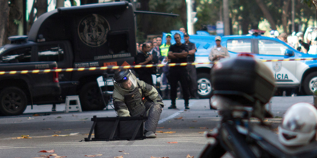 A member of the bomb squad examines a backpack deemed suspicious that was left at the door of an apartment building, in the Leblon neighborhood of Rio de Janeiro. Photo / AP