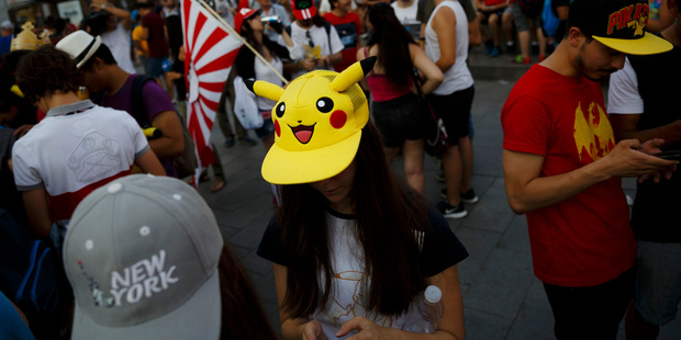 Fans play the highly addictive 'Pokemon Go' game during a gathering in central Madrid, Spain. New York authorities want to ban registered sex offenders from playing the game. Photo / AP