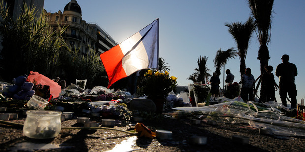 A French flag stands stall amongst a floral tribute for the victims killed during a deadly attack, on the famed Boulevard des Anglais in Nice. Photo / AP