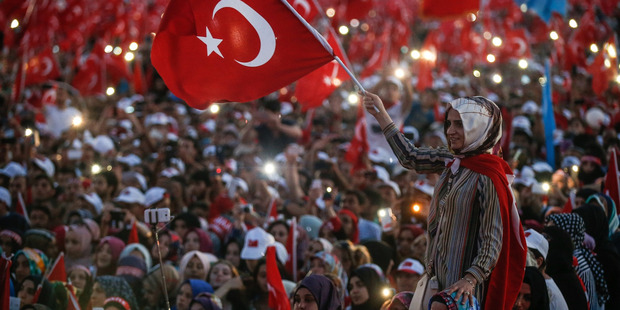 A Turkish woman waves a flag of her country during the speech of President Recep Tayyip Erdogan at the Democracy and Martyrs' Rally in Istanbul. Photo / AP