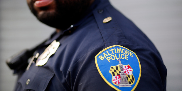 Baltimore Police Department Officer Jordan Distance stands on a street corner during a foot patrol in Baltimore. Photo / AP