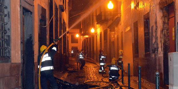 Firefighters battle a fire that reached the old centre of Funchal, the capital of Portugal's Madeira Island. Photo / AP