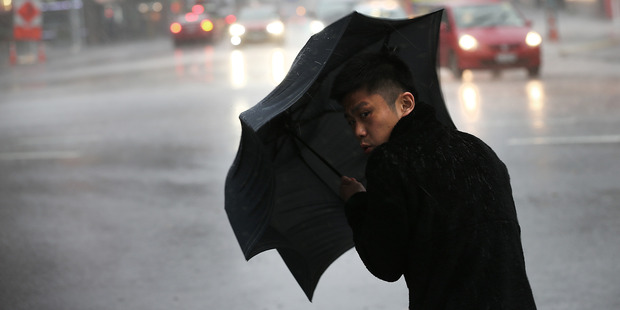 People brave the bad weather in Auckland CBD. Photo / Doug Sherring