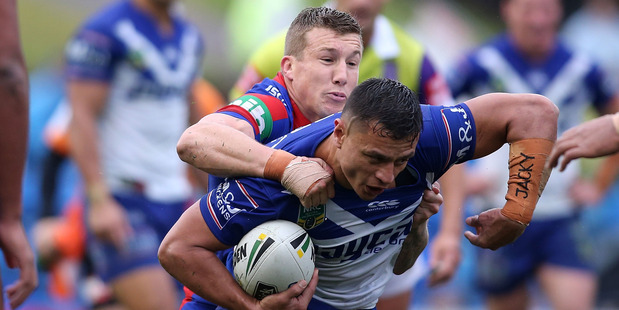 Sam Perrett of the Bulldogs is tackled by Trent Hodkinson of the Knights during Canterbury's win over Newcastle yesterday. Photo / Getty Images