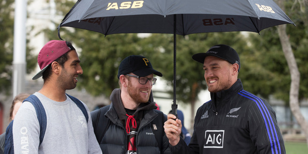 Israel Dagg keeps fans Neelesh Rampal and Tom Hayhof dry at Aotea Square. Photo / Brett Phibbs