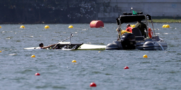 Milos Vasic and Nenad Bedik, of Serbia, are helped out of the water after capsizing while competing in the men's pair heat during the 2016 Summer Olympics in Rio de Janeiro. Photo / AP.
