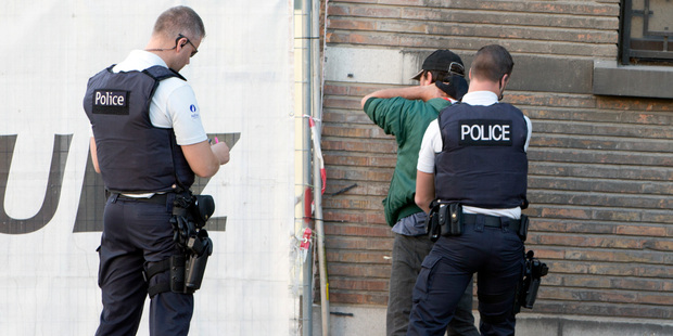Police officers check the identification of a man near the police headquarters in Charleroi. Photo / AP
