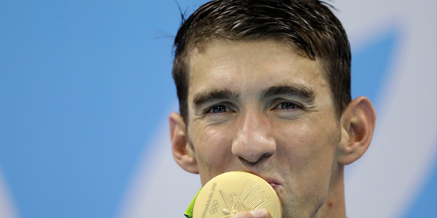 United States' Michael Phelps kisses his gold medal after the men's 4x100-meter freestyle final during the swimming competitions at the 2016 Summer Olympics. Photo / AP.