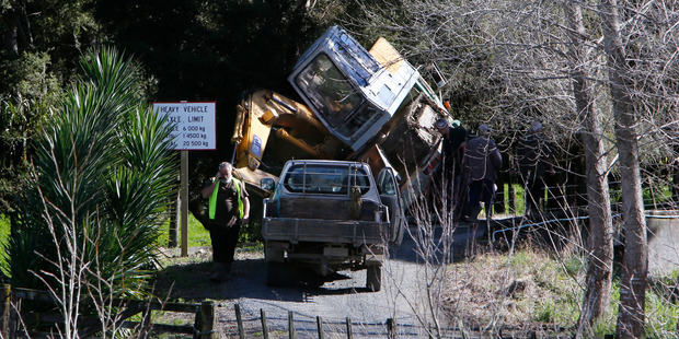 A truck carrying a digger over a one lane bridge on Mulberry Lane hangs precariously on the edge. Photo / John Stone