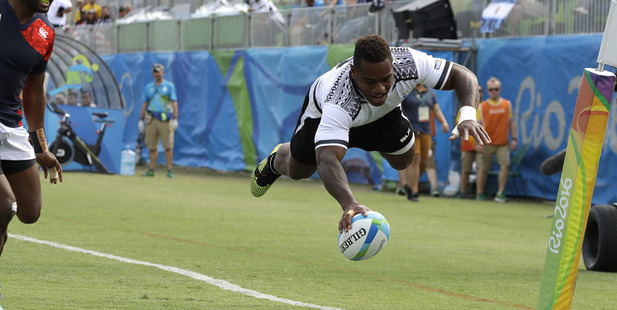 Fiji's Josua Tuisova, right, scores a try as Japan's Kameli Soejima, watches during the semi final of the men's rugby sevens. Photo / AP
