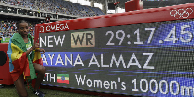 Ethiopia's Almaz Ayana poses next to a scoreboard showing her new world record in the women's 10,000-metre final. Photo / AP