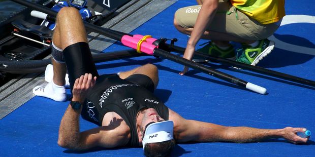 New Zealand's Mahe Drysdale collapses after winning the gold in the men's single sculls rowing final. Photo / AP