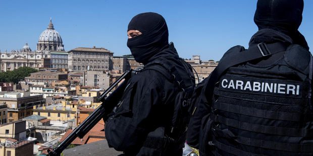 Carabinieri (Italian paramilitary police) special unit's officers patrol the area next to St Peter's Basilica, background left, in Rome. Photo / AP