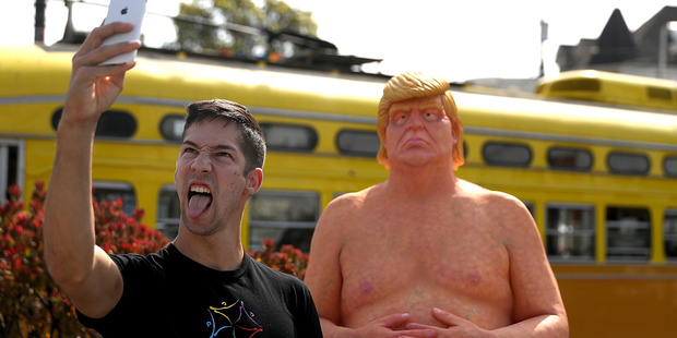 A passerby takes a selfie with a statue of presidential nominee Donald Trump in San Francisco. Photo / Getty Images