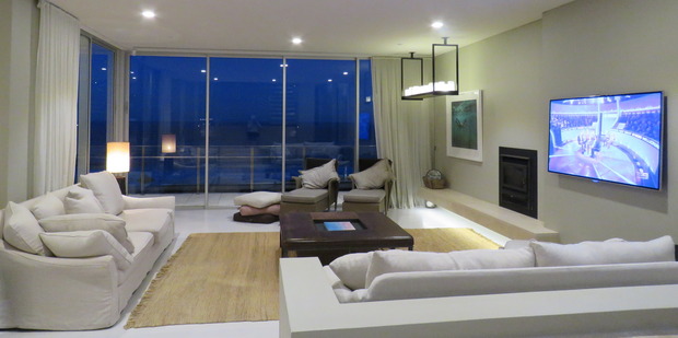 The house's spacious lounge is the perfect place to relax with a movie and a glass of wine after a day at the beach. Photo / Supplied