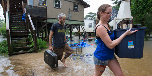 Getting out ahead of the flood, Michael Tramonte and Nikki Conger clear their possessions from their house. Photo / AP