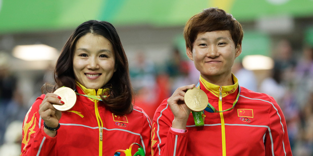 Gong Jinjie, left, and Zhong Tianshi, right, of China hold their gold medals on the podium of the Women's team sprint finals at the Rio Olympic Velodrome. Photo / AP.