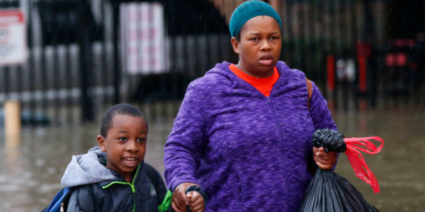 Residents wade through floodwaters from heavy rains in the Chateau Wein Apartments in Baton Rouge. Photo / AP