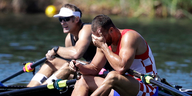 Silver medalist Damir Martin, of Croatia, right, reacts as gold medalist Mahe Drysdale, of New Zealand, rests after the men's rowing single sculls final. Photo / AP.