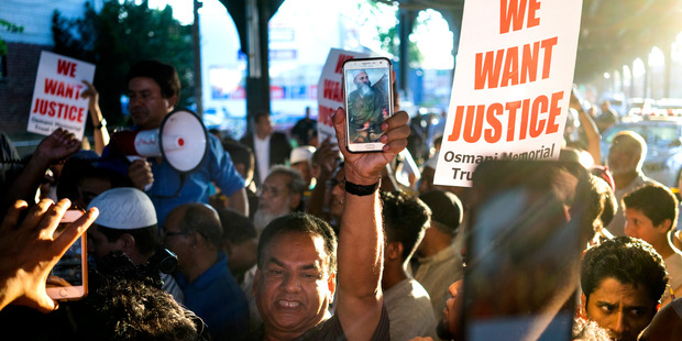 People gather for a demonstration near a crime scene after the leader of a New York City mosque and an associate were fatally shot in a brazen daylight attack. Photo / AP