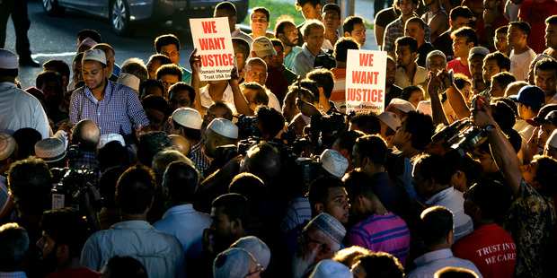 People gather for a demonstration near a crime scene after an imam and his friend were fatally shot while walking home from a mosque. Photo / AP
